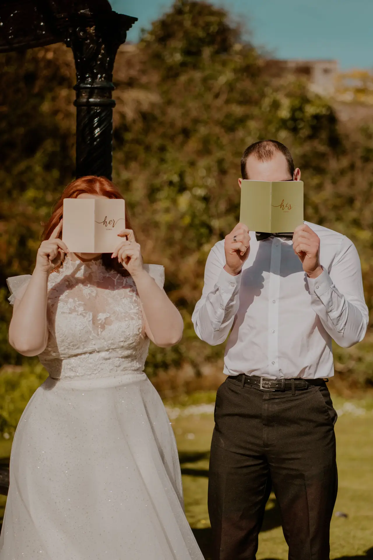 bride and groom holding vow booklets 