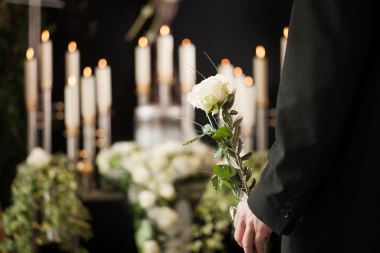 grieving family member holding a white rose to symbolise the life of their loved one during cremation in Newtownabbey Crematorium
